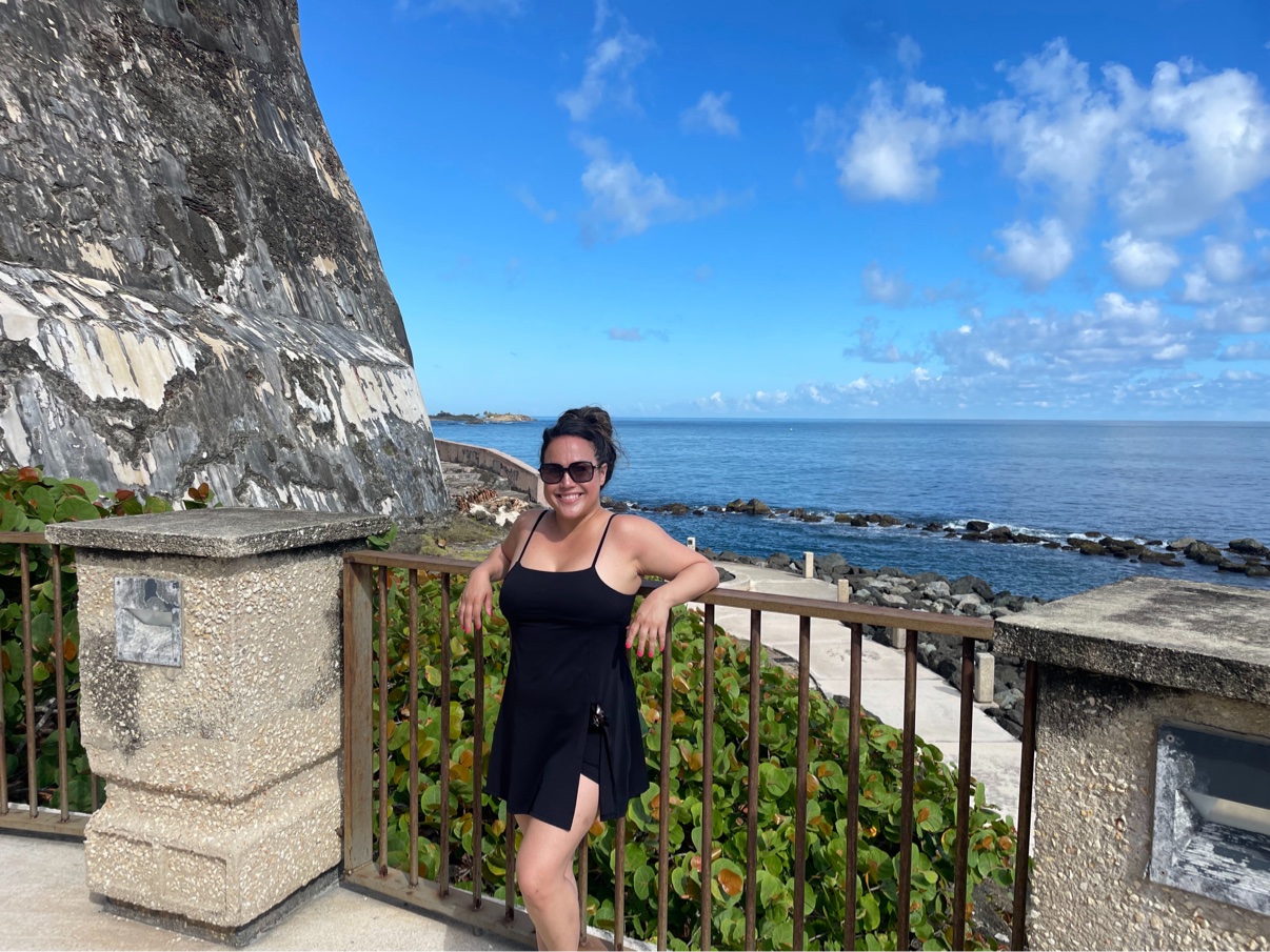 Fatima overlooking the ocean beside a historic coastal fort