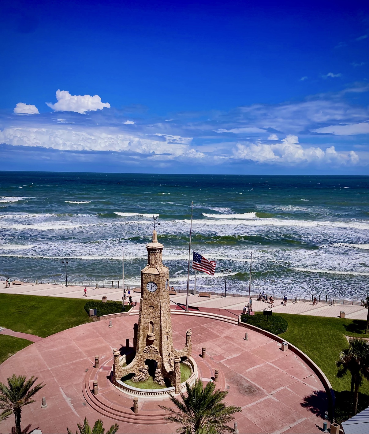 Oceanfront stone clock tower with an American flag